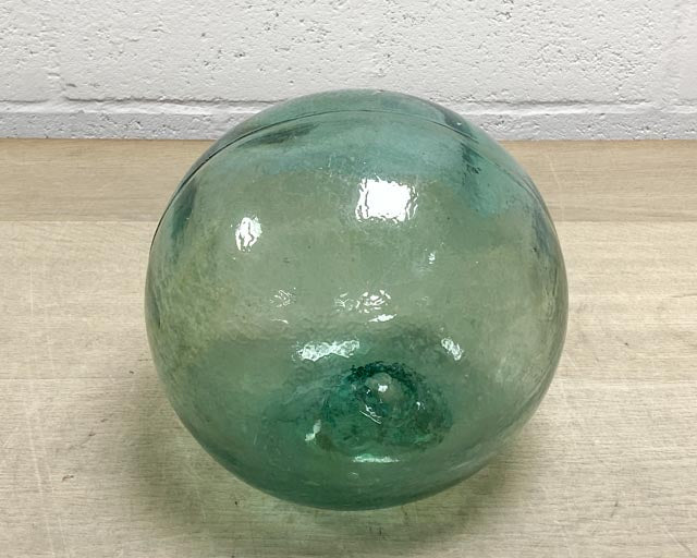 A large old Japanese green glass fishing float, complete with its